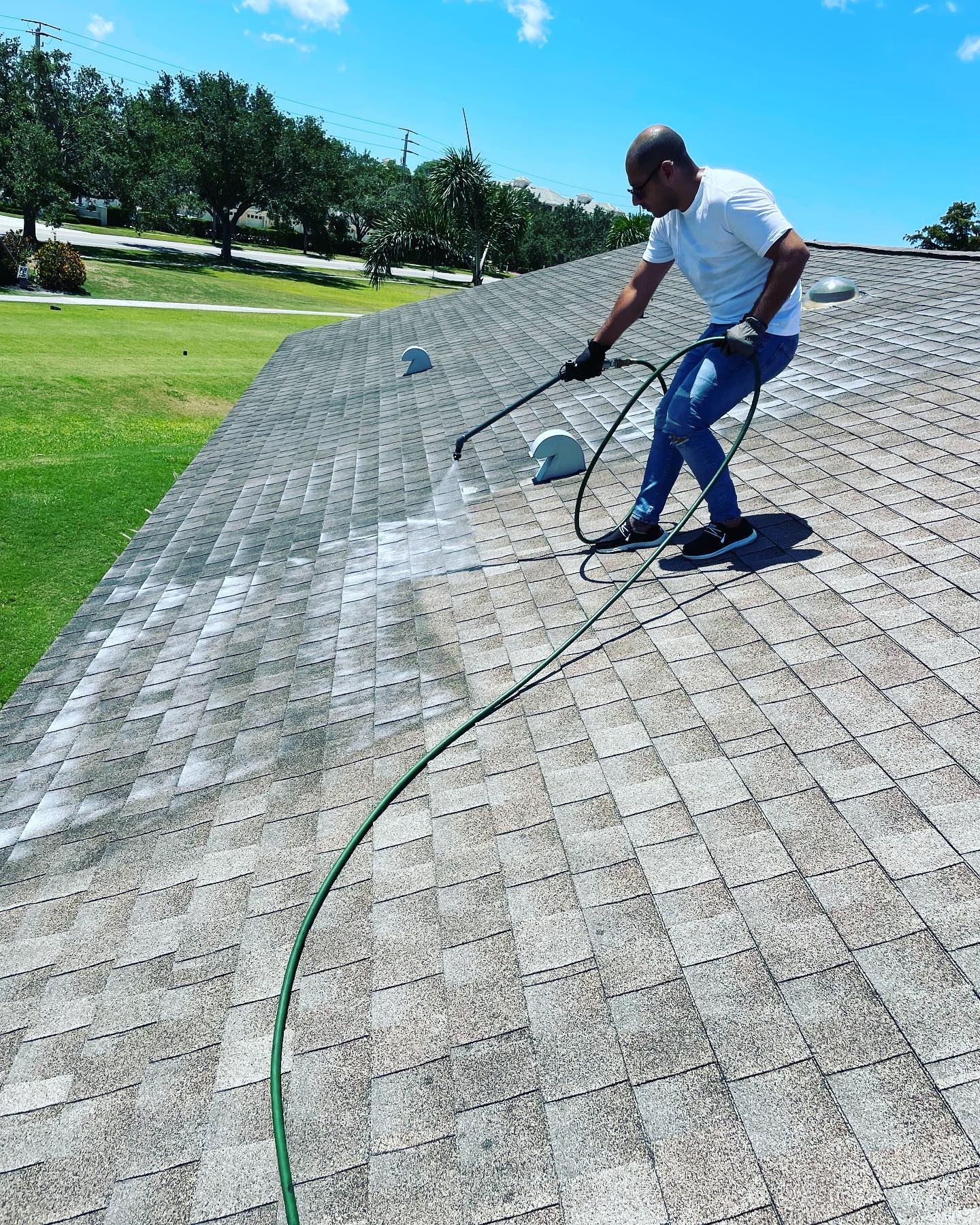 Technician applying Peak 301 bio-oil across aging shingles