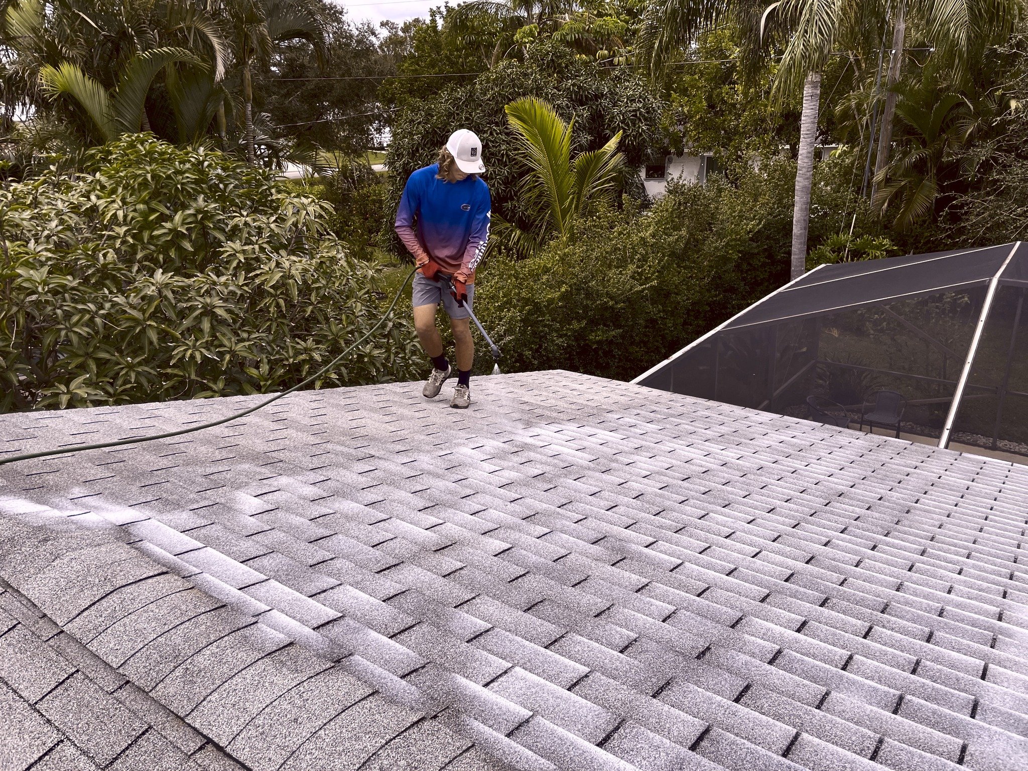 Large Florida shingle rejuvenation project with technician on roof