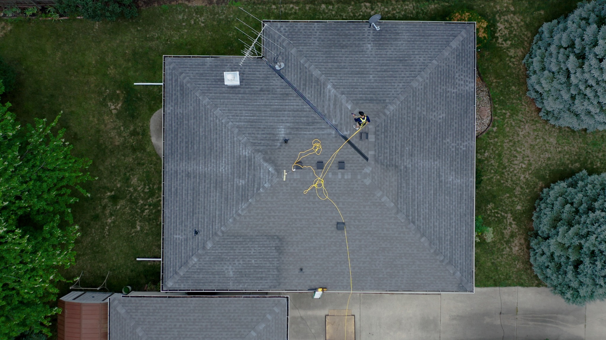 Drone view of shingle rejuvenation treatment in progress on an asphalt shingle roof