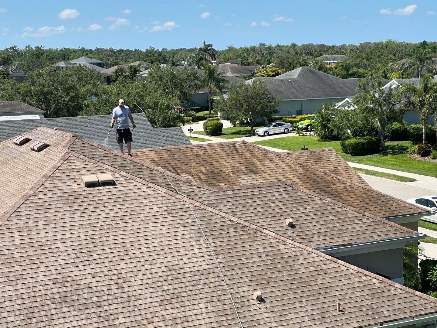 Wide aerial photo of a Florida shingle roof being treated with shingle rejuvenation